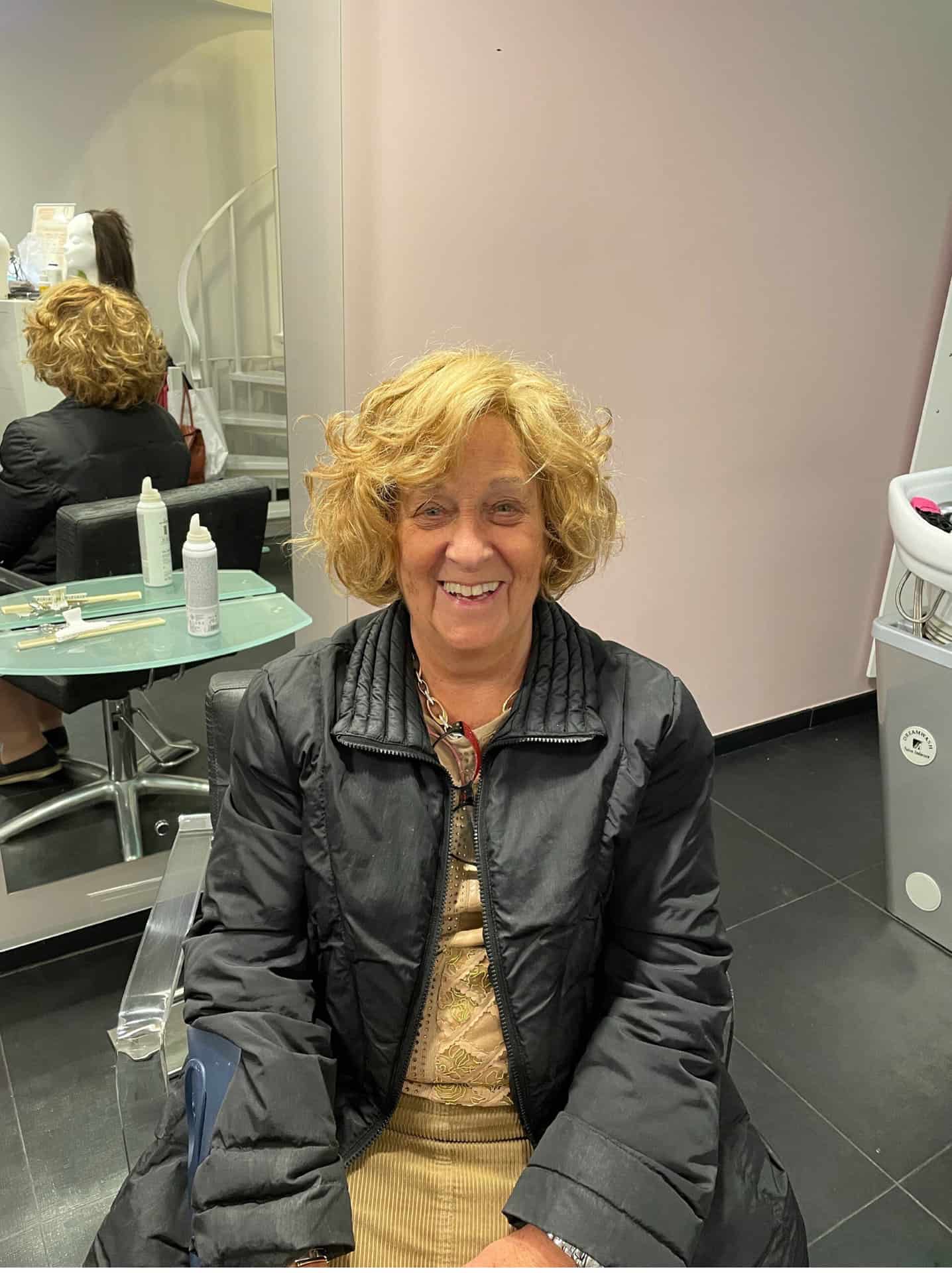 Een vrouw die haarbehandeling en -herstel krijgt in een salonstoel.